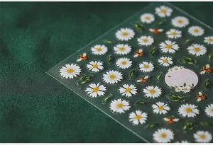Macro detail of Little Daisy and bee themed nail art stickers on a textured background