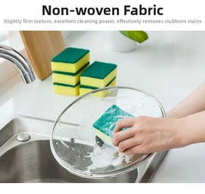 Dual-sided sponge cleaning a glass lid with green scouring pad and yellow foam layers