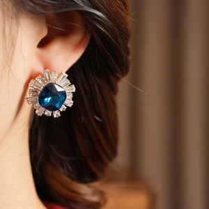 Close-up of vintage blue zircon earrings worn by model for elegant style display