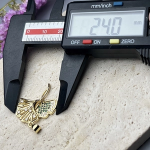 Detailed size measurement of a gold ginkgo leaf pendant with green and white zircons