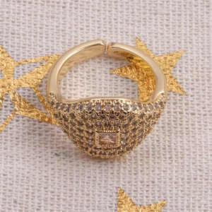 Close-up of gold-plated hip hop ring with pave zircons and square center stone