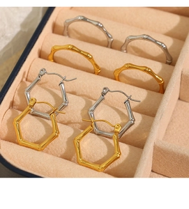 Detailed macro view of geometric bamboo style gold and silver hoop earrings in a jewelry box