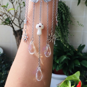 Silver multi-chain arm jewelry featuring sun and star charms with crystal prism pendants