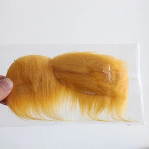 Detail view of yellow synthetic mustache accessory packaged in a clear plastic bag