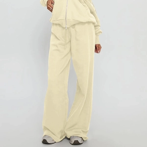 Détail d'un sweat à capuche zippé crème et d'un pantalon large à cordon de serrage