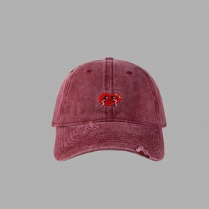 Close-up of heart embroidery and distressed worn details on burgundy baseball cap