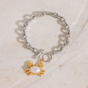 Gliederkette in Silber mit goldenem Krabben-Perlenanhänger und OT-Verschluss auf Stein