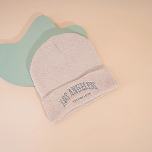 Gros plan sur la broderie Los Angeles Vintage sur un bonnet en maille beige doux