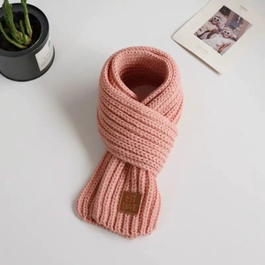 Pink knit baby beanie with dinosaur spikes and cute leather label for winter warmth
