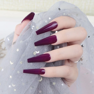Close-up of deep purple long coffin press-on nails with a high-gloss UV finish