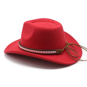 Detail of red wool felt cowboy hat with leather belt, silver stars, and tassels