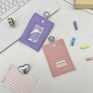 Detailed view of quilted heart card holders in pink and purple with metal D-rings