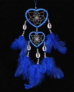 Close-up of blue heart-shaped dreamcatcher with delicate feathers and shell beads