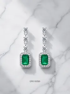 Vue macro de longues boucles d'oreilles émeraude en argent S925 serties de cristaux pavés