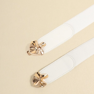 Detail of white elastic waist belts featuring abstract golden metal buckles and PU leather ends