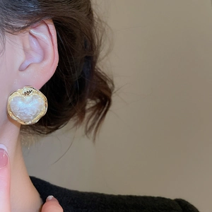 Dettaglio ravvicinato di orecchini a cuore placcati in oro 16K con trama vintage
