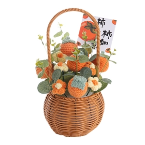 Handmade crochet persimmon basket with white flowers in a small brown woven bag