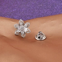 Detailed view of silver flower brooch with zircon stones and butterfly clutch backing