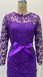 Detailed view of purple lace dress featuring a satin bow belt and hollow-out embroidery