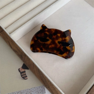 Detail of a cat-shaped tortoise shell hair claw clip made of acetate in a display box