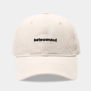 Close-up of beige cotton baseball cap featuring black betweenaod letter embroidery