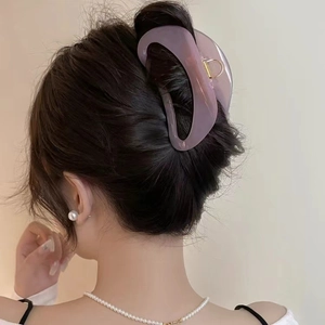 Grande pince à cheveux lavande minimaliste pour femme fixant un chignon sur cheveux épais