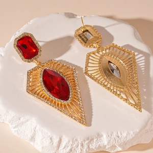 Detailed view showing the front and back of gold geometric earrings with a red crystal