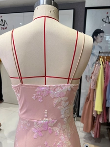 Detail of pink sequin embroidery and thin straps on back of a slim evening dress