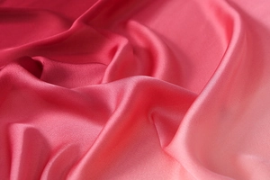 Nahaufnahme von seidigem Satin mit rosa Farbverlauf und elegantem, weichem Glanz