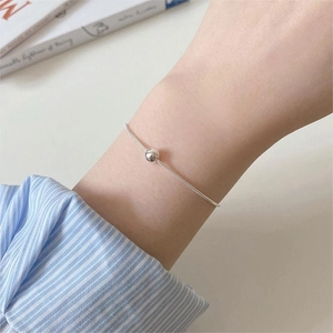 Minimalist S925 sterling silver snake bone bracelet with single round bead on female wrist