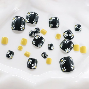 Minimalist square press-on toenails featuring black daisy prints and bright yellow finish