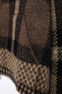 Dettaglio della trama in maglia a rombi marrone e nera con morbide fibre di lana