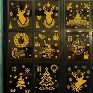 Macro detail of golden glitter Christmas reindeer and snowflake window static stickers