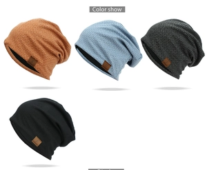 Detailed view of knitted beanies with checkered patterns and leather logo patch accents