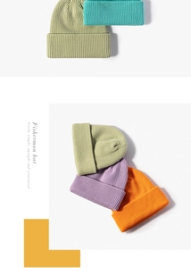 Flat lay of colorful ribbed knit fisherman beanies in green, teal, purple and orange colors