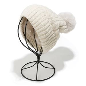 Détail du bonnet d'hiver en maille avec large bord côtelé et pompon en fausse fourrure