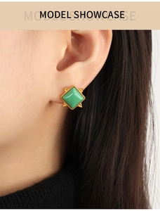 Close-up of model wearing a vintage square green natural stone earring with gold-plated trim