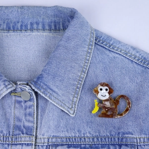 Fashionable acrylic monkey brooch with tortoiseshell pattern pinned on denim jacket