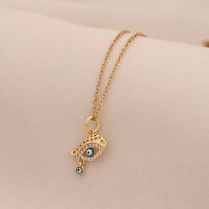 Detail of gold Evil Eye necklace featuring blue stones, crystals and hanging star charm