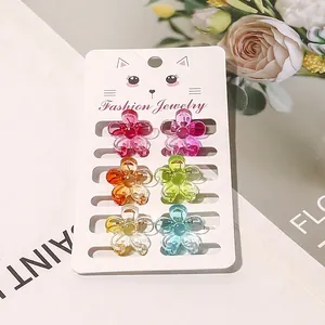Detail of six mini flower hair claws in colorful jelly colors on a jewelry card