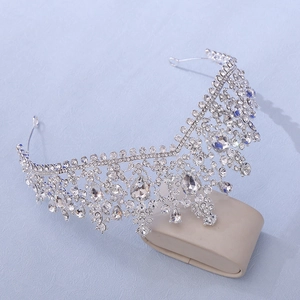 Detailed view of a silver bridal crown with glittering rhinestones on a display stand