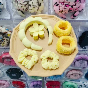Detailed set of yellow plush headbands and hair accessories on a beige display tray