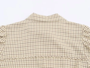 Detail of beige plaid blouse back yoke with shoulder pleats and woven fabric texture