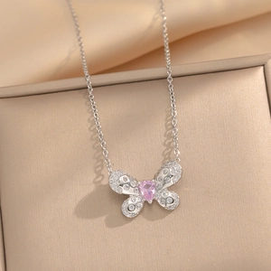 Silver butterfly pendant necklace with pink teardrop stone and zircon on beige jewelry box