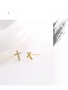 Detail of gold cross stud earrings featuring pavé cubic zirconia with high quality finish