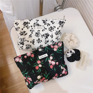 Close-up of floral cotton cosmetic bags with simple wish labels and hair accessories