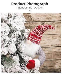 Close-up of a Christmas gnome decoration with a snowflake knit hat next to a snowy tree
