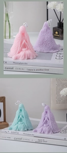 Artistic hooded woman shaped scented candles in soft pink, purple and cyan pastel tones