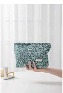 Detail of green floral canvas makeup bag with small white flower patterns and fabric label