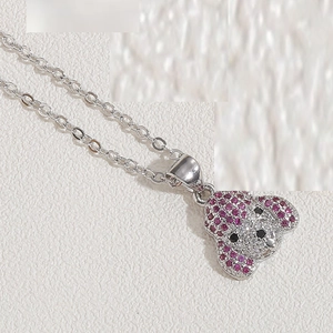 Macro shot of a cute puppy pendant with pink and white cubic zirconia on a silver chain